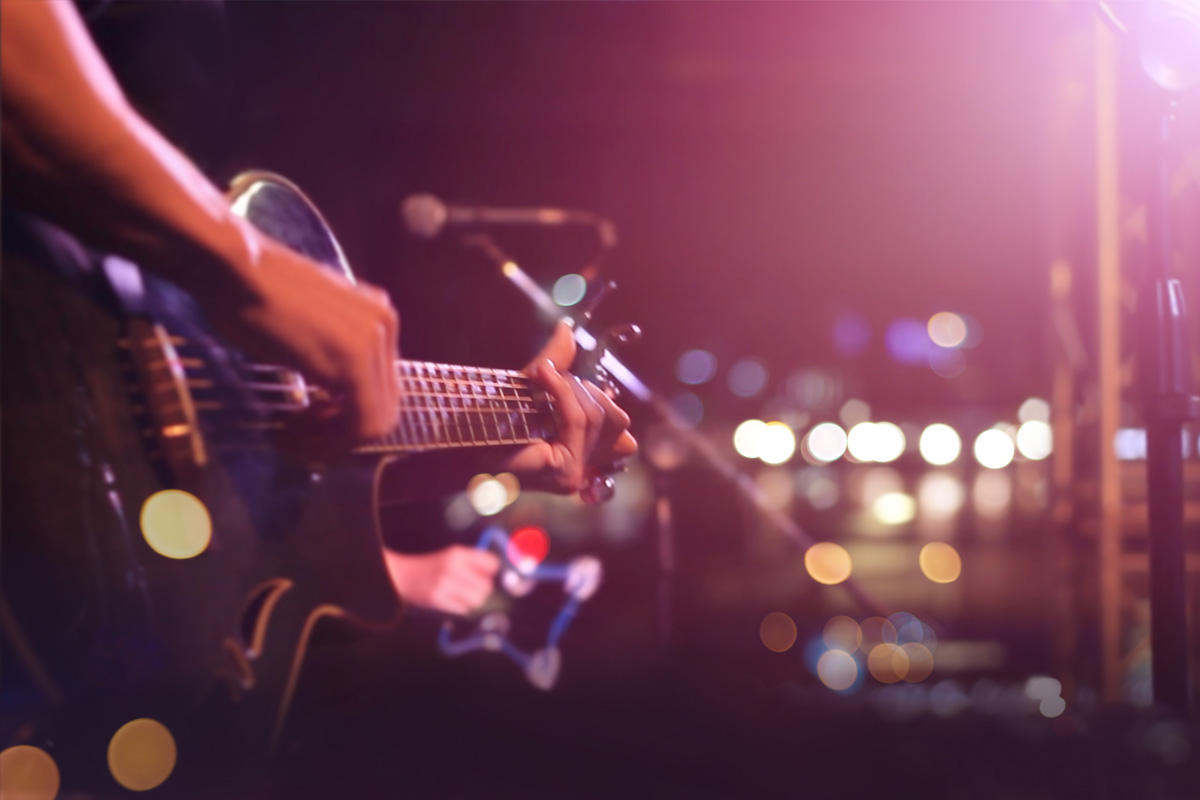 Photo of guitar being played on stage